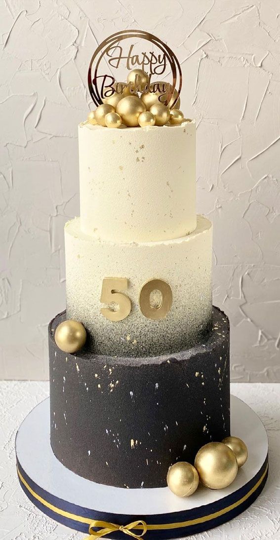 a black and white cake with gold decorations on it's tiers that says happy 50th