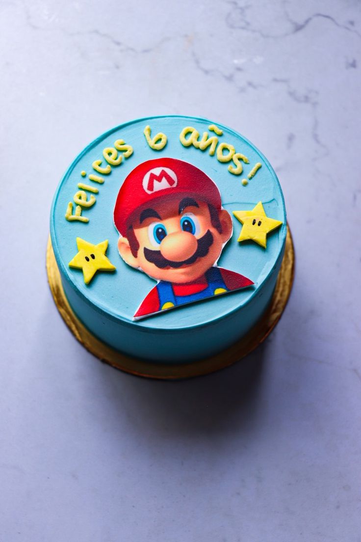 there is a small cake that has a mario on it's face and stars around it