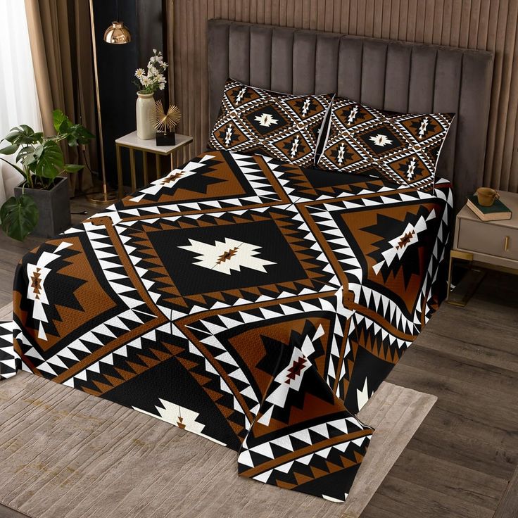 a bed covered in a brown and black blanket