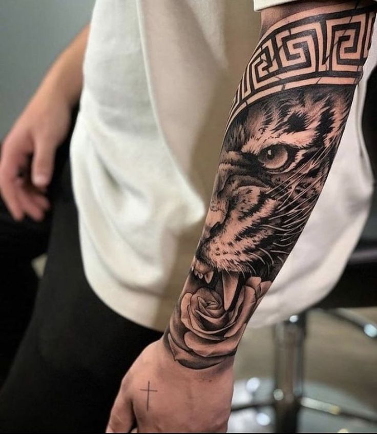 a man's arm with a tiger and rose tattoo on the left side of his arm