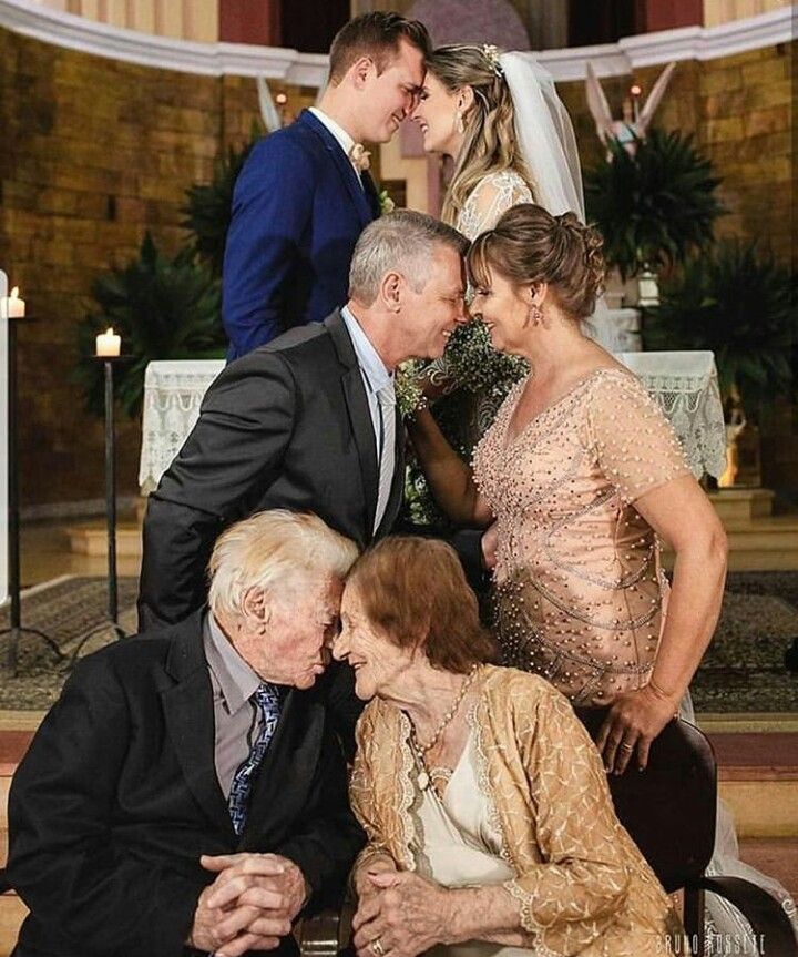 an old man and woman kissing in front of two older men