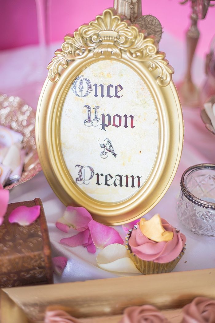 there is a sign that says once upon a dream next to some cupcakes