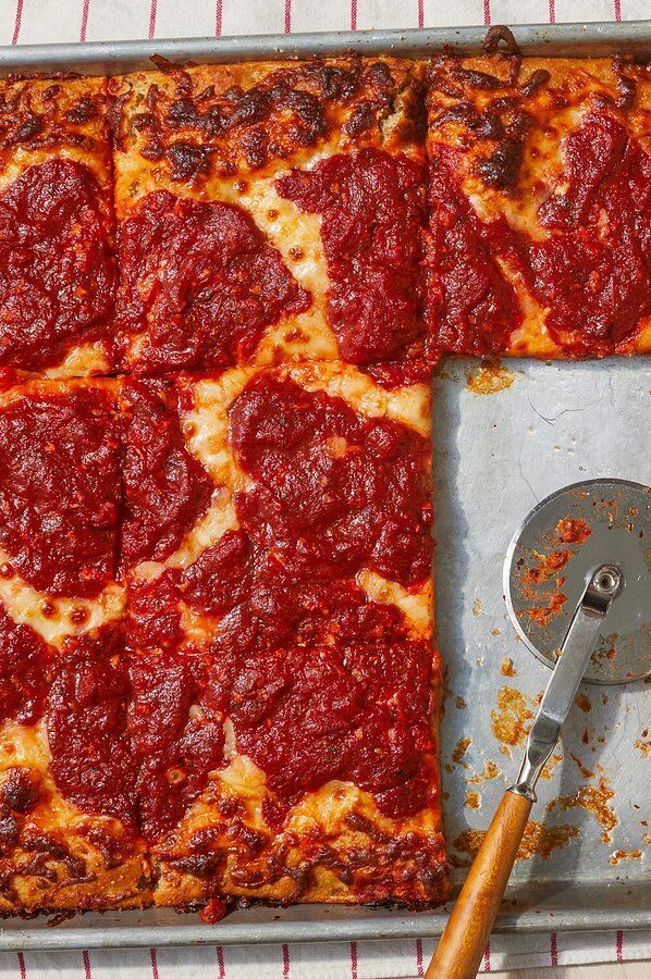 a square pizza sitting on top of a pan next to a spatula