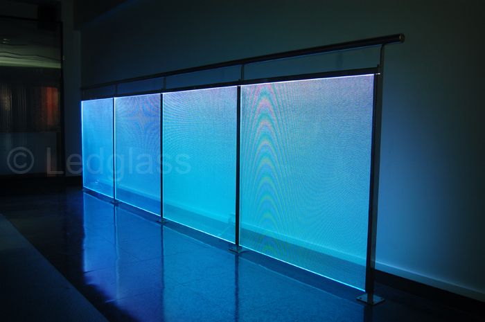 an empty room with blue light coming through the glass walls and reflecting on the floor