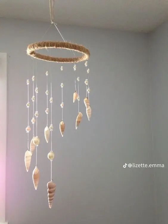 a mobile made out of seashells hanging from the ceiling in a child's room