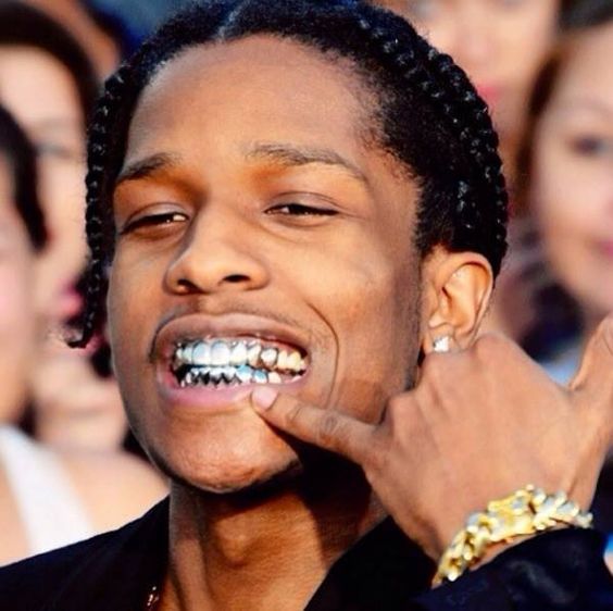 a close up of a person with braces on his teeth and people in the background