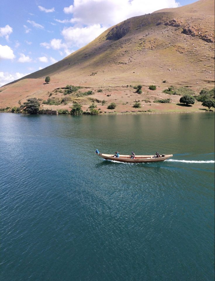 a boat with two people on it in the middle of a large body of water