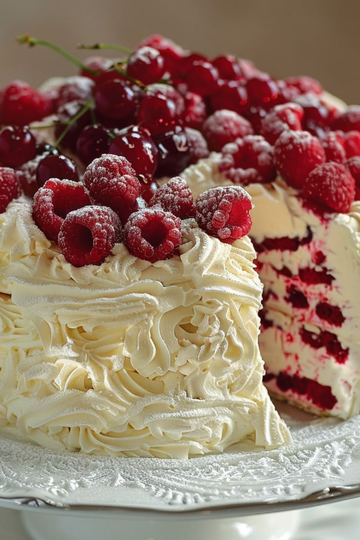 a cake with white frosting and raspberry toppings on top is sitting on a plate