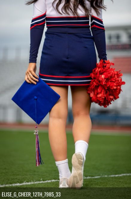 a cheerleader is walking on the field with her pom poms in hand