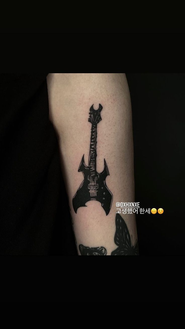 a black and white photo of a guitar tattoo