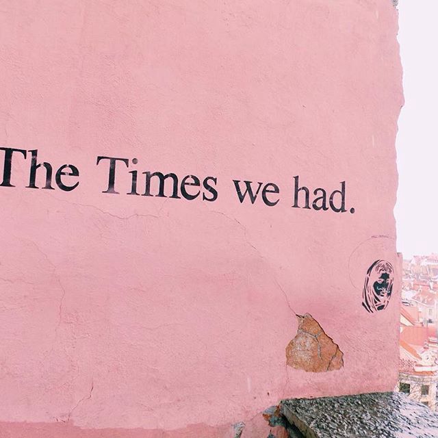 a pink wall with the words the times we had written on it and a clock tower in the background