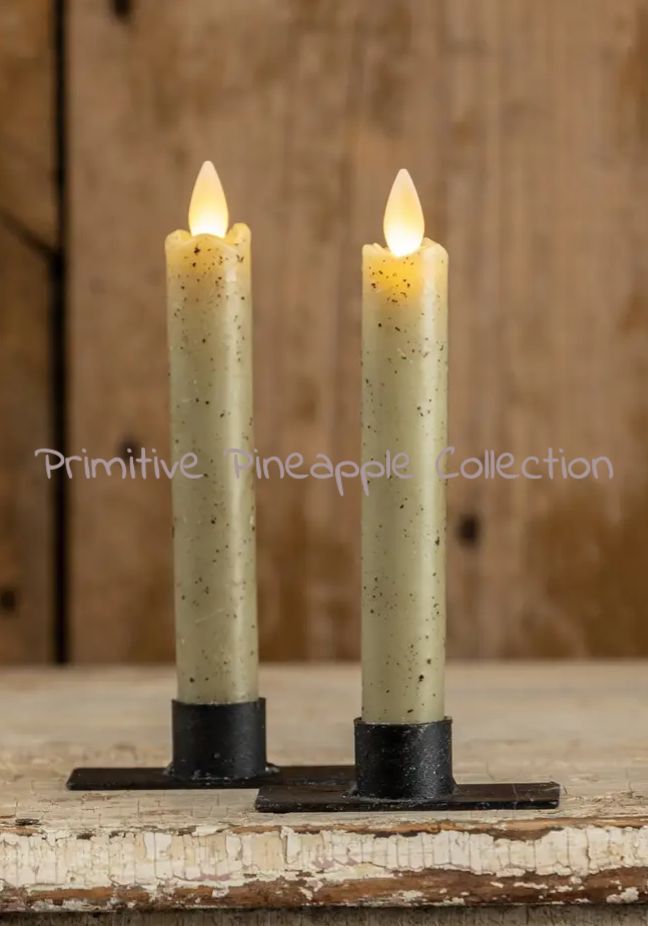 two lit candles sitting on top of a wooden table