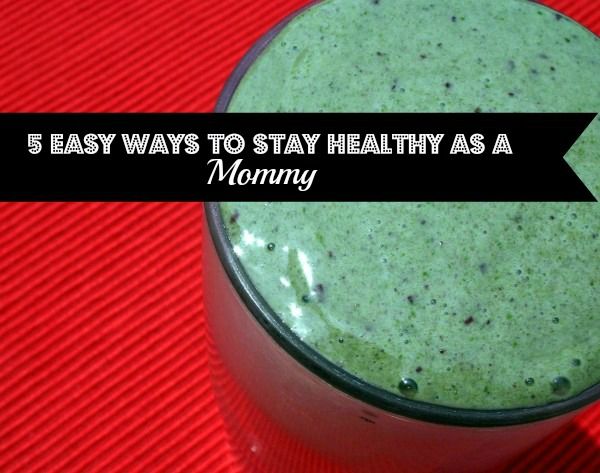 a glass filled with green smoothie sitting on top of a red table