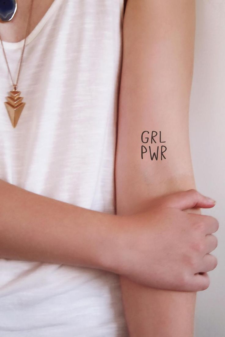 a woman with a tattoo on her arm that says girl pwr in black ink