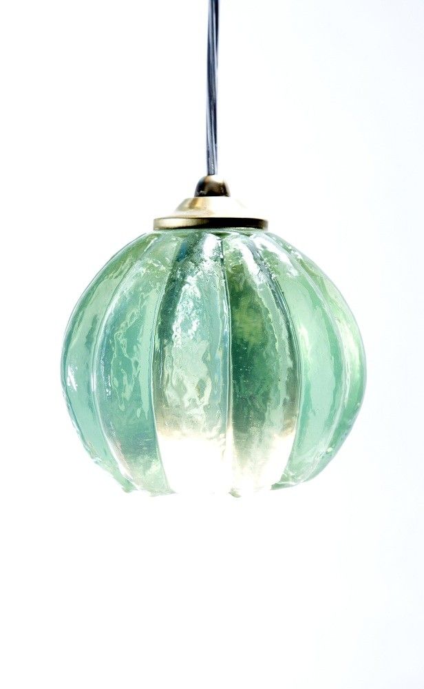 a green glass light hanging from a ceiling