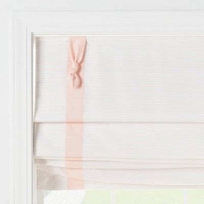 a white window with pink ribbon hanging from it's side