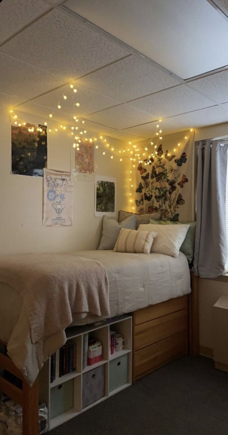 a room with a bed, bookshelf and lights on the wall above it