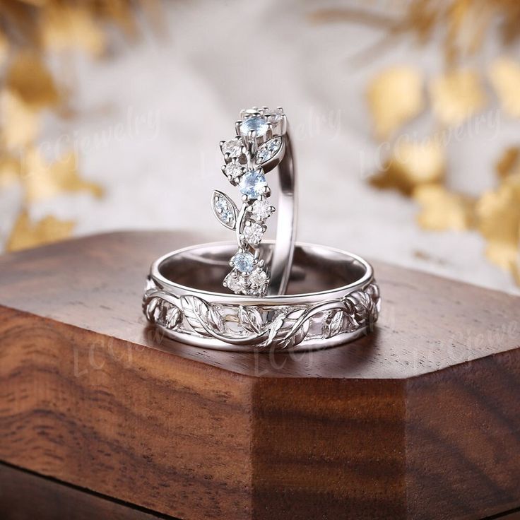 two wedding rings sitting on top of a wooden box