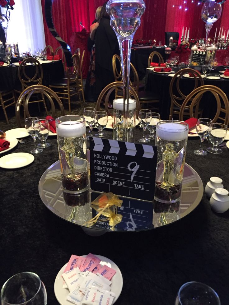 a table topped with lots of glasses filled with liquid and candy bar signs on top of it