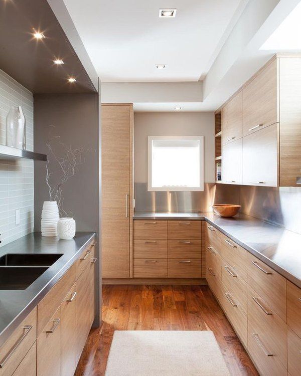 a kitchen with wooden cabinets and stainless steel counter tops, along with a rug on the floor