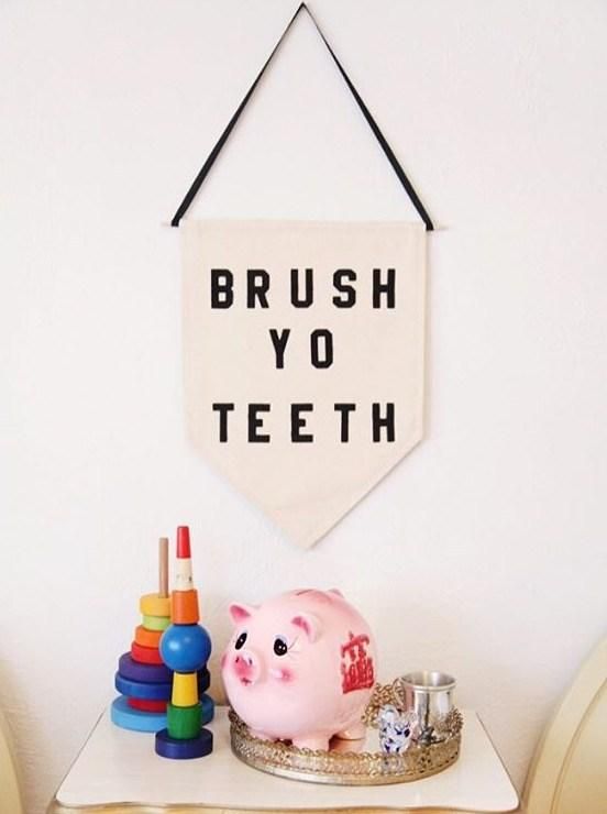 a pink pig sitting on top of a table next to a white banner that says brush yo teeth