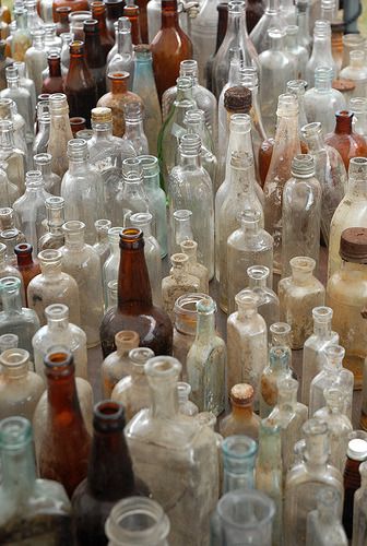 many empty glass bottles are lined up together