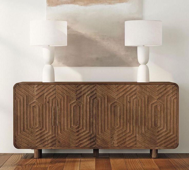 an art deco sideboard with two lamps on it and a painting above the cabinet