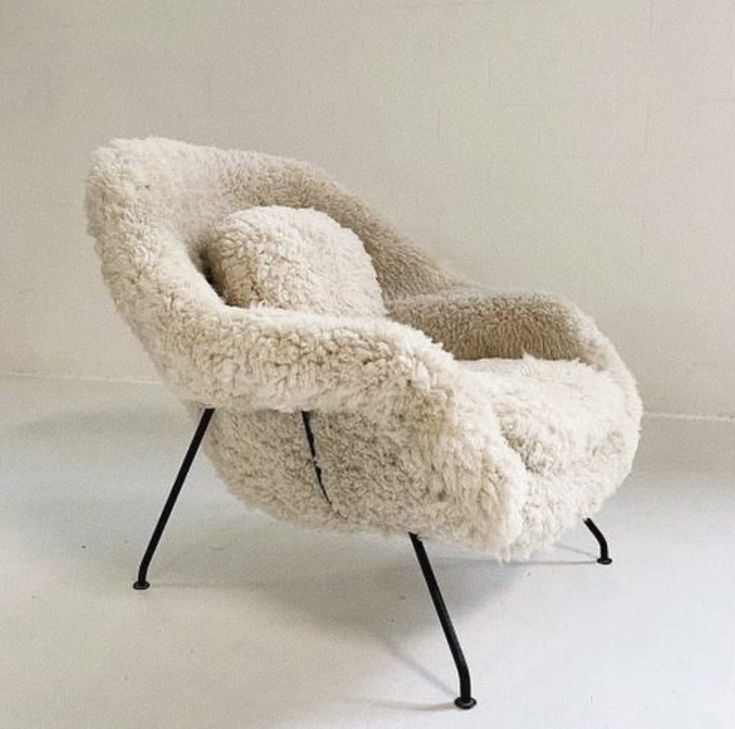 a chair made out of sheep's wool with black legs and an iron base