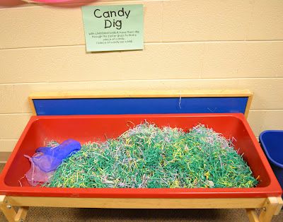 a red tray filled with grass next to blue bins