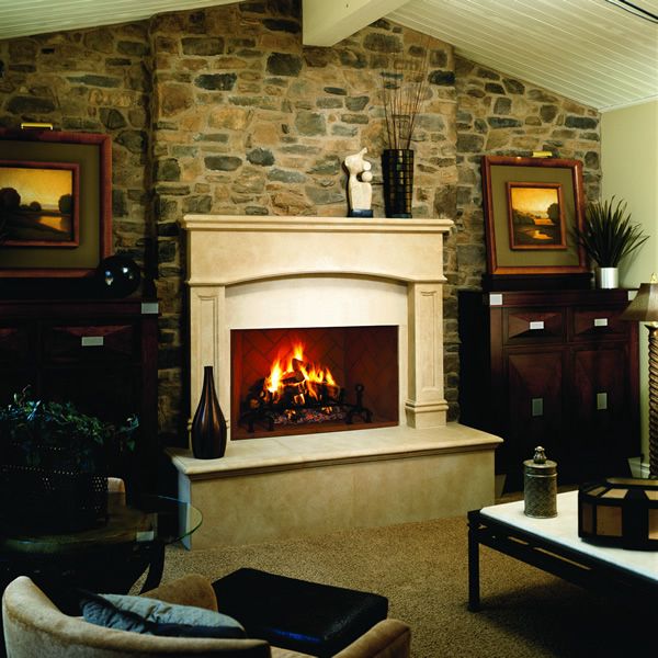 a living room with a fire place in the center and pictures on the wall above it