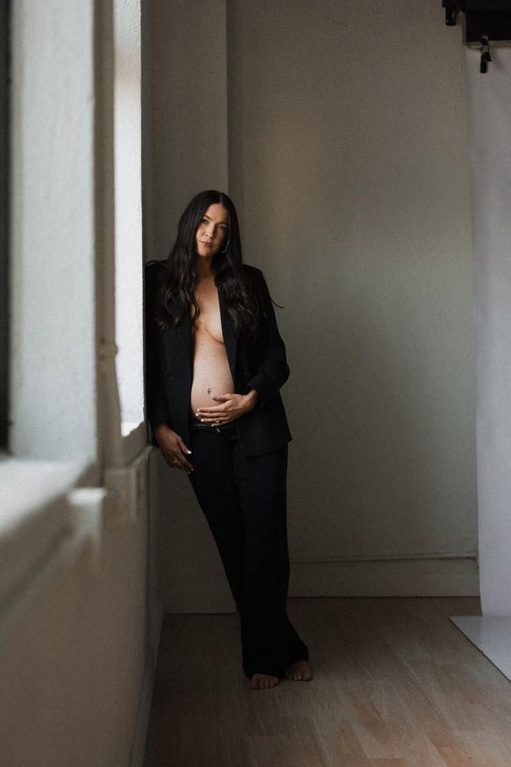 a pregnant woman standing in an empty room