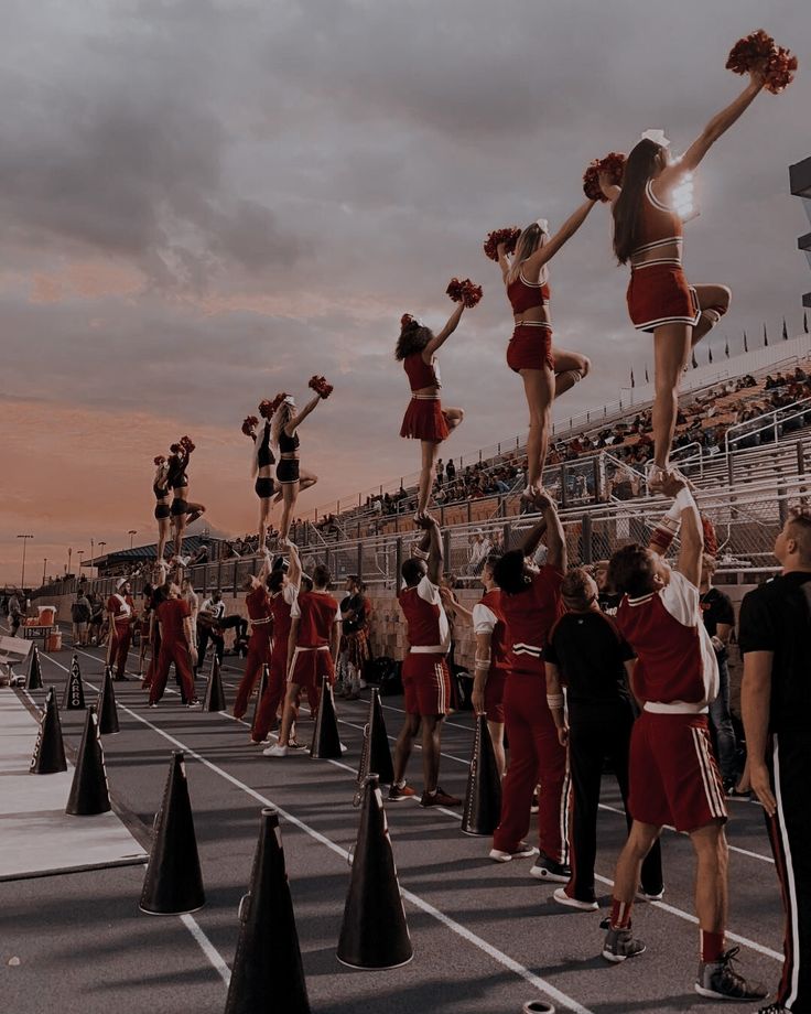 a group of cheerleaders standing on top of black cones in the middle of a race track