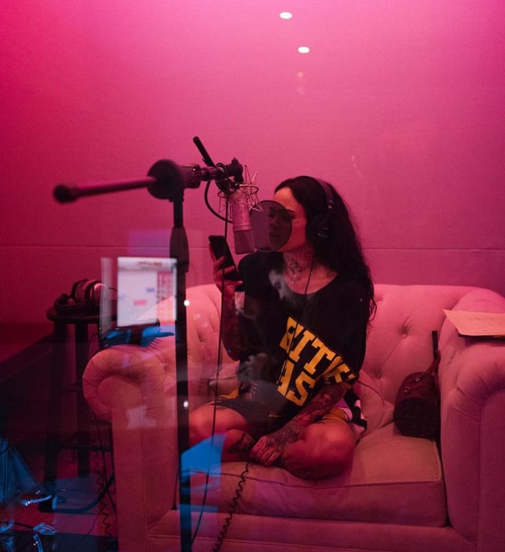 a woman sitting on top of a couch next to a microphone