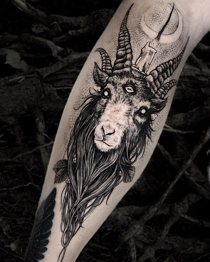 a goat with long hair and horns on his head is shown in this black and white tattoo