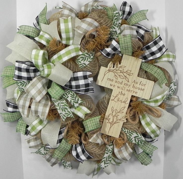 a wreath with a cross on it and some burlocks hanging from the front