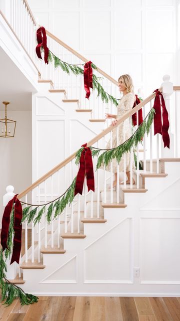 a staircase decorated with christmas garland and red bows