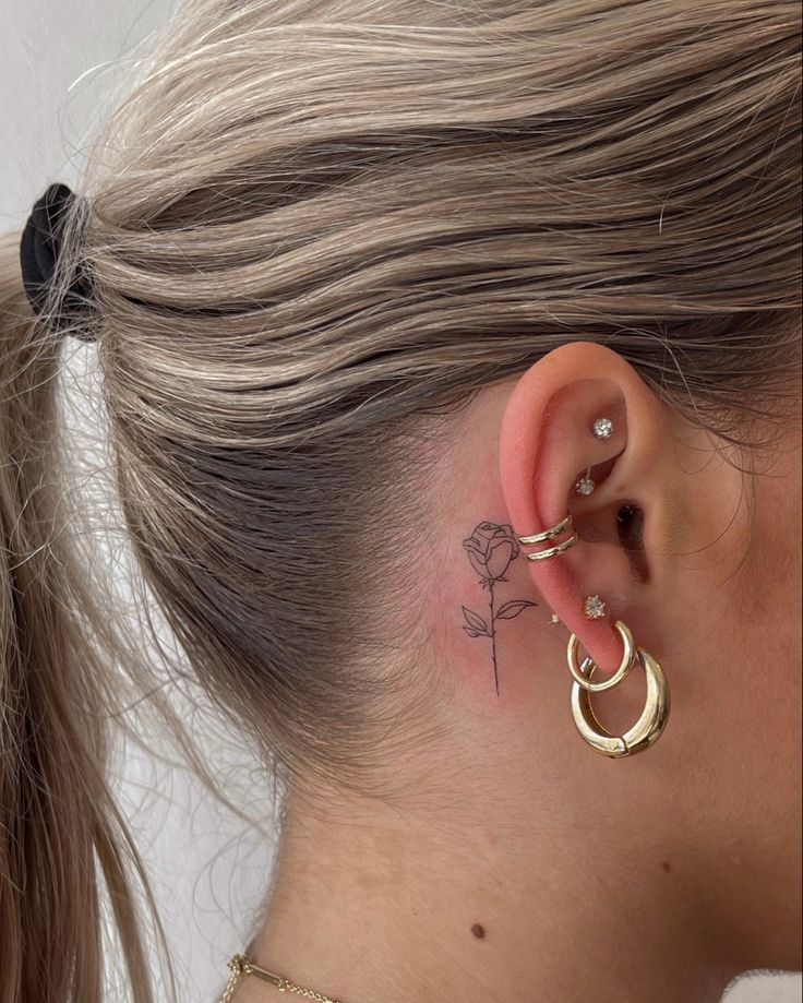 a woman's ear has a small tattoo on it