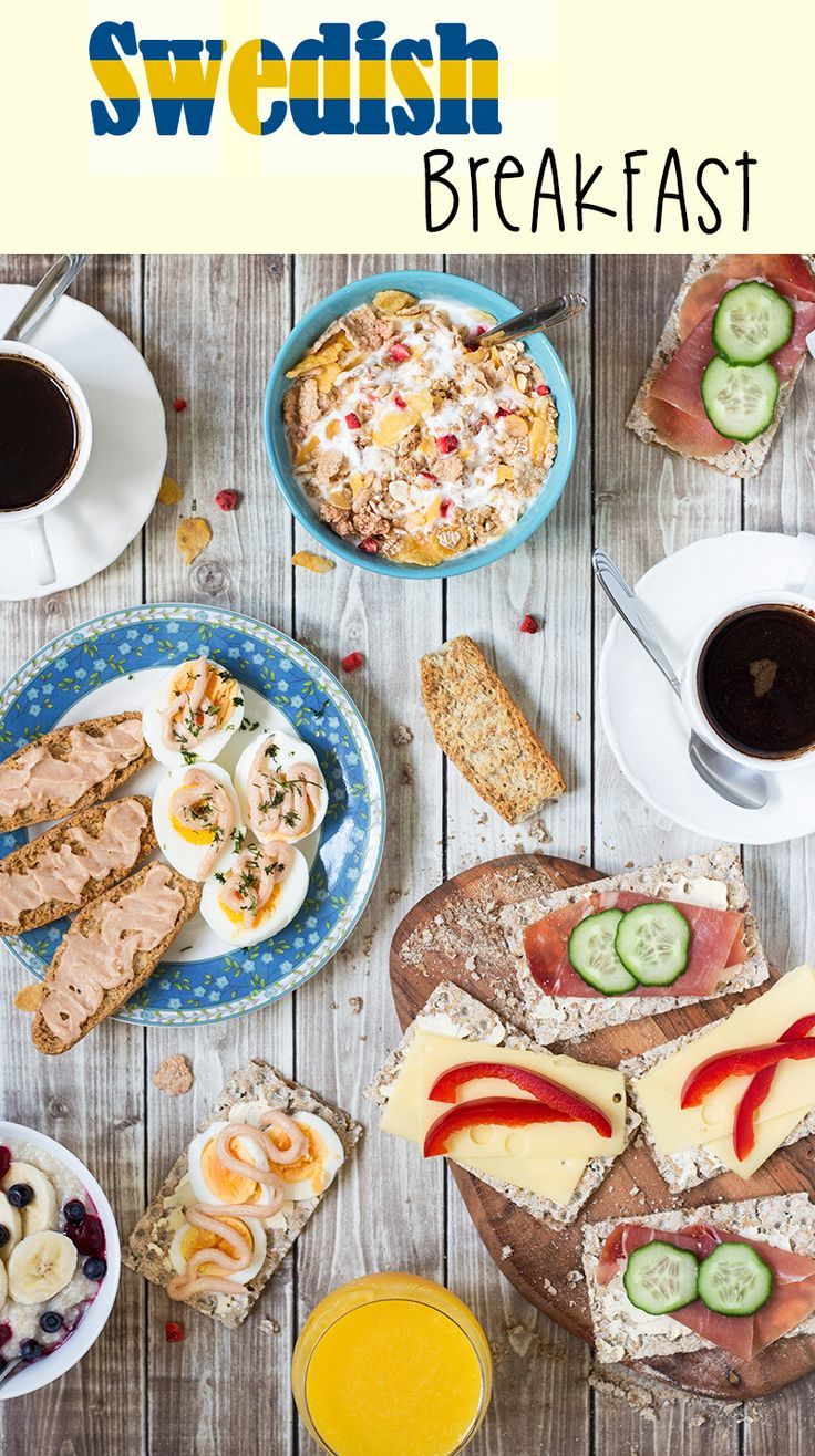 a table topped with plates of food next to cups of coffee and fruit on top of a wooden table