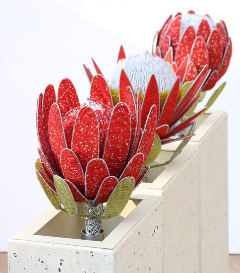 two red flowers sitting on top of cement blocks