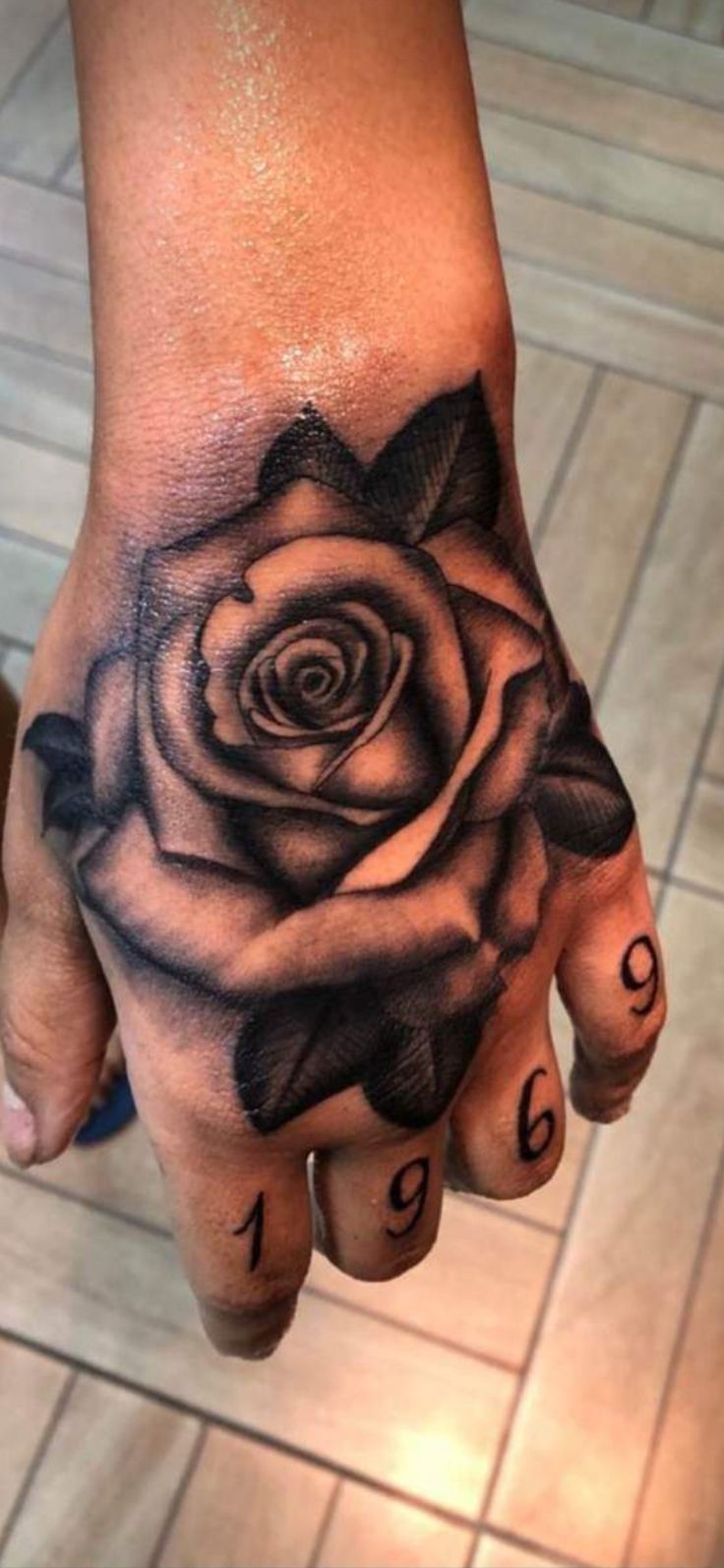 a woman's hand with a rose tattoo on it