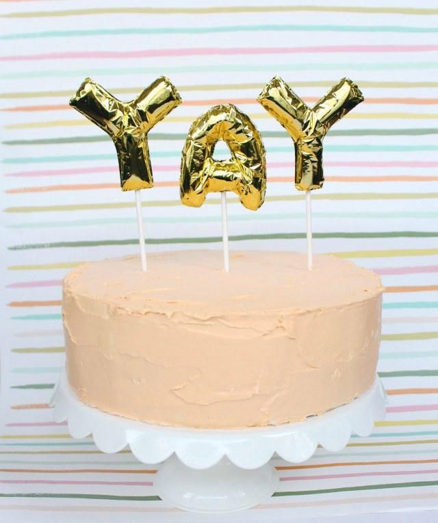 a birthday cake with gold foil letters on top