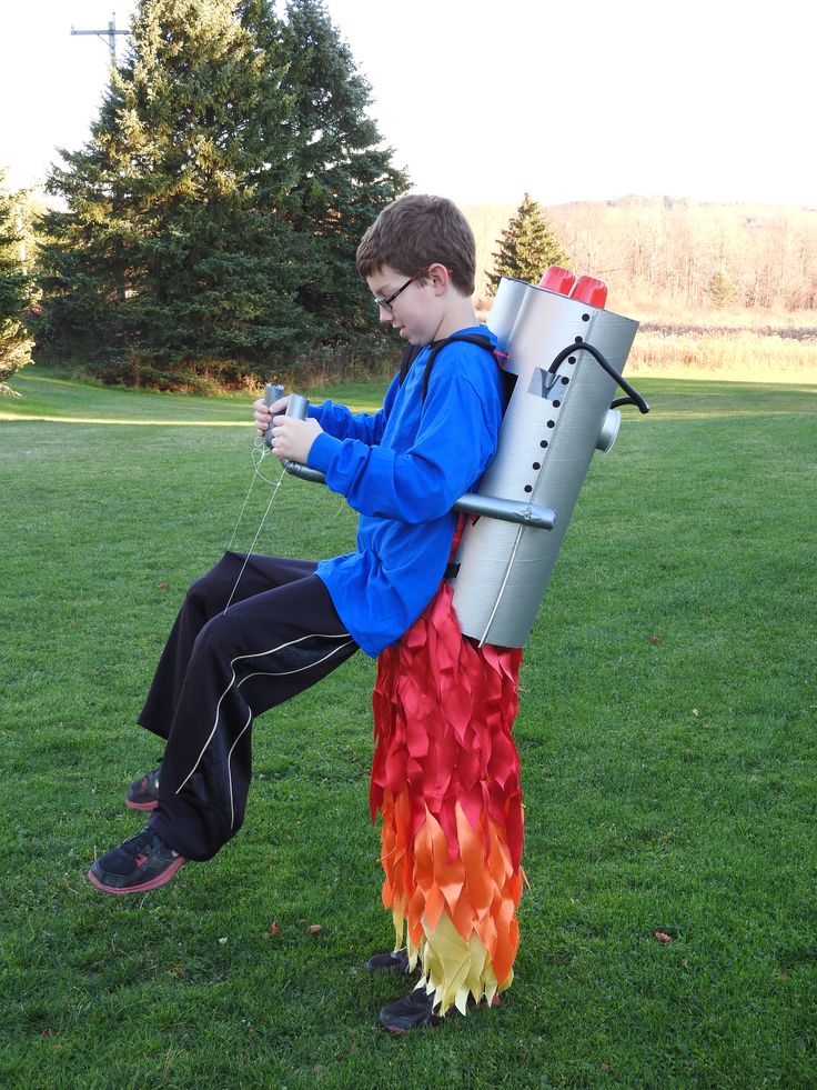 a young man sitting on top of a fire hydrant in the middle of a field