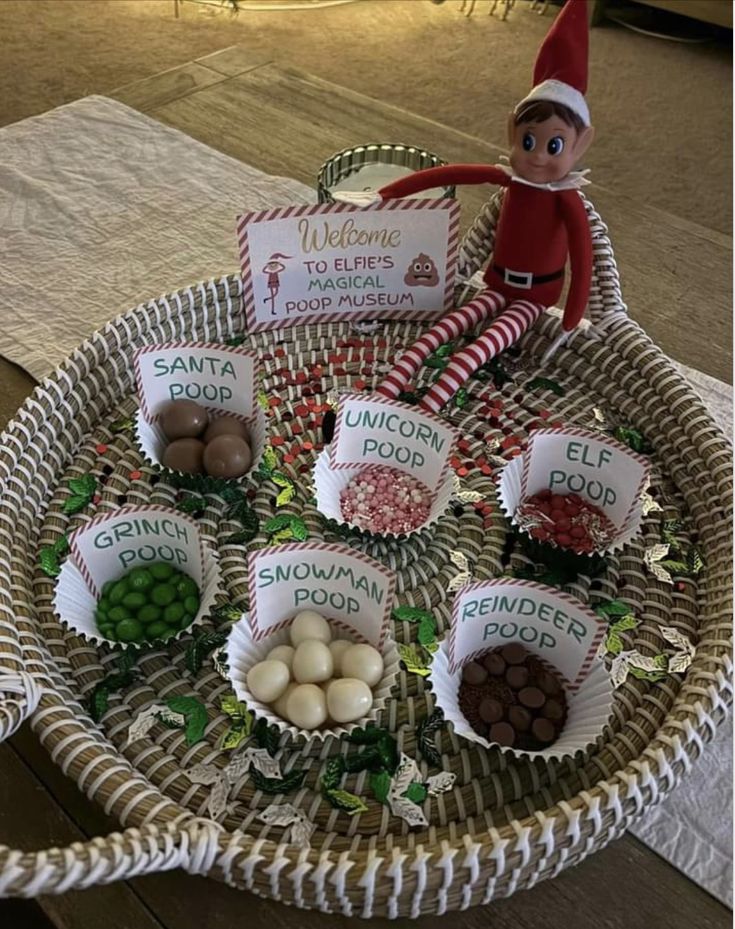 an elf is sitting on top of a basket filled with candies and other foods