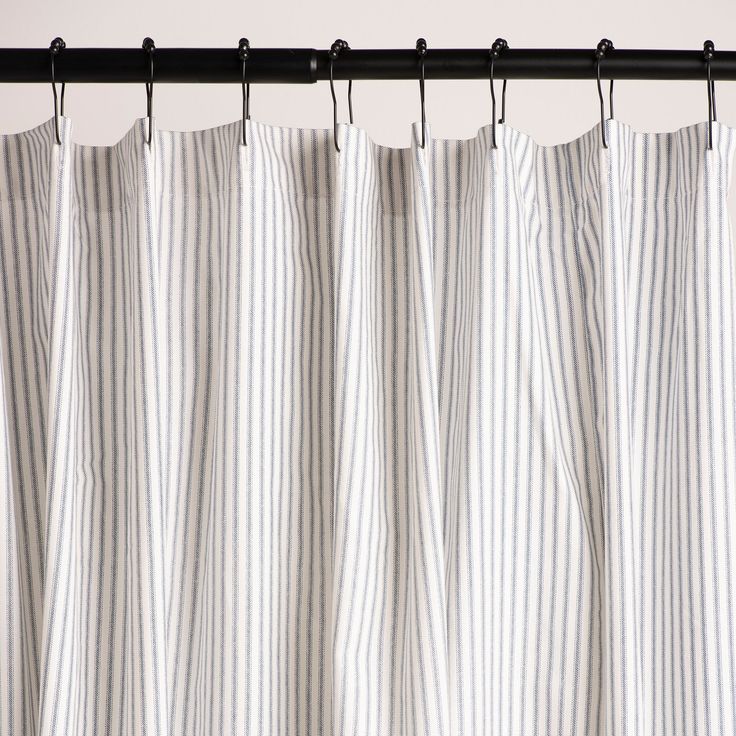 a white and black striped curtain hanging from a metal rod