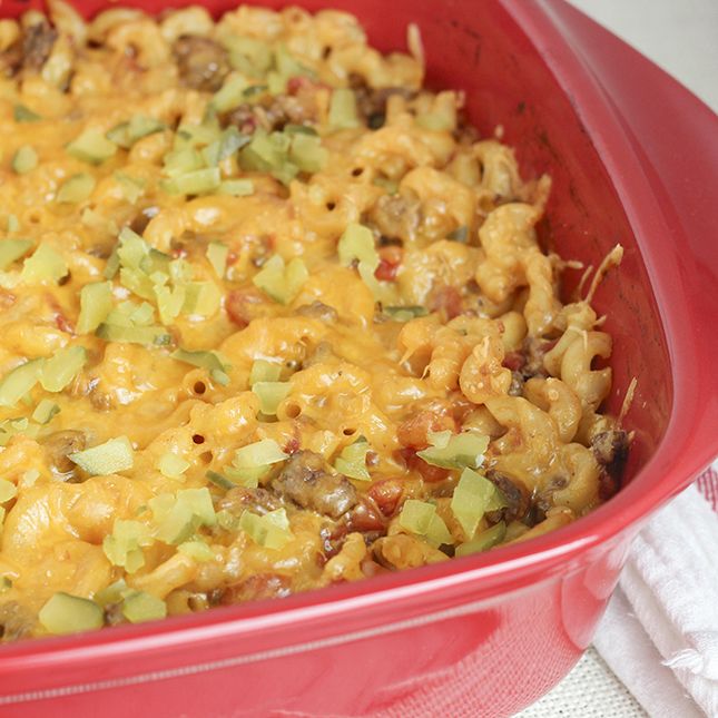 a red casserole dish filled with macaroni, cheese and other toppings