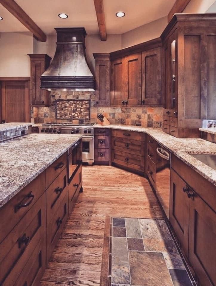 a large kitchen with wooden cabinets and granite counter tops, along with a stainless steel range hood