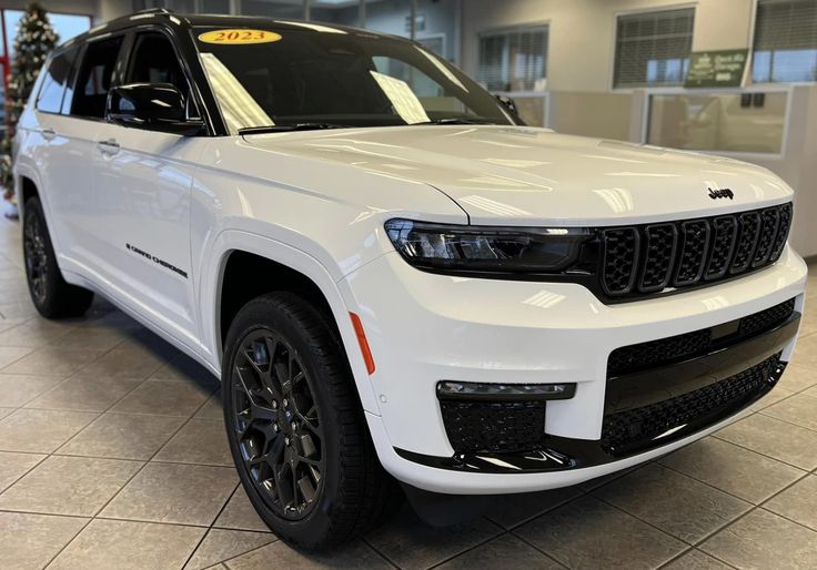 a white jeep is parked in a showroom