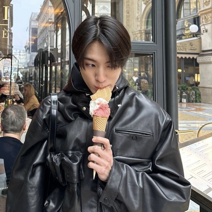 a man eating an ice cream cone on the street