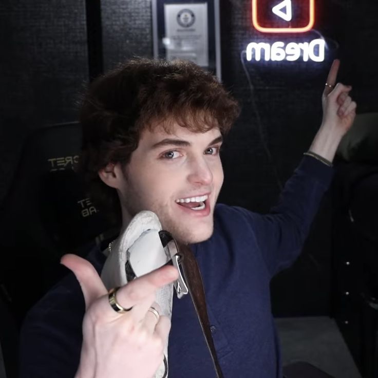 a young man holding up his peace sign