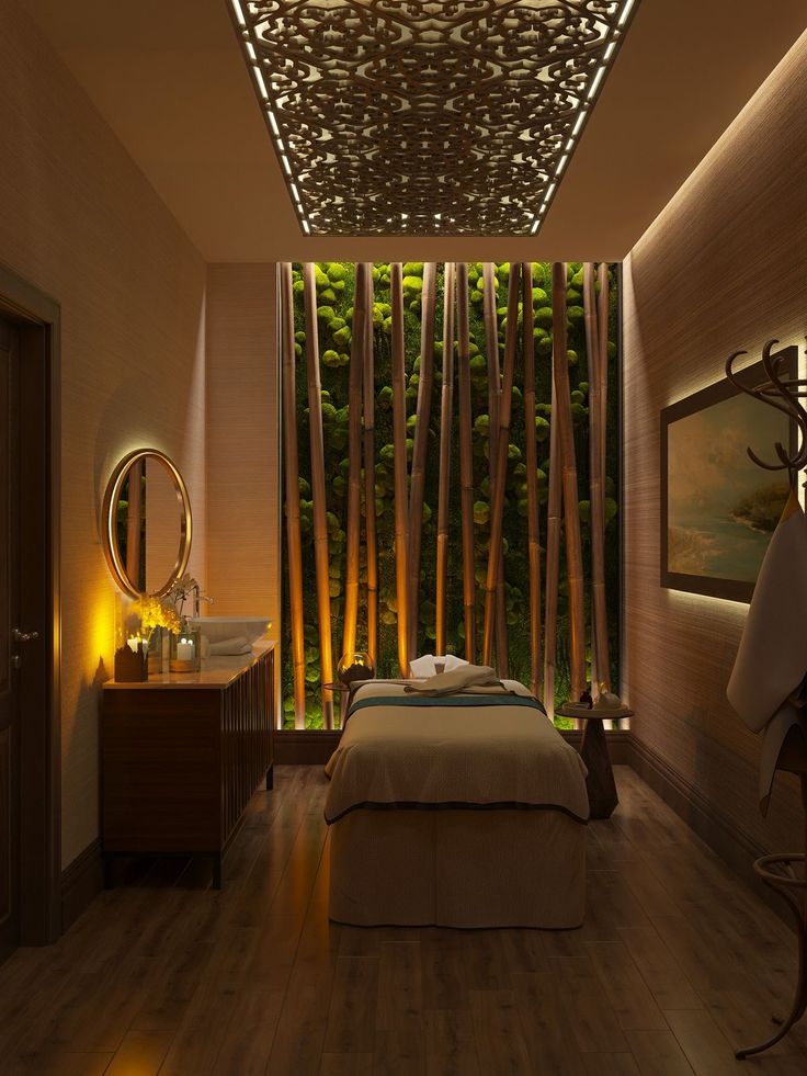 a spa room with wooden floors and bamboo trees on the wall, along with a large mirror